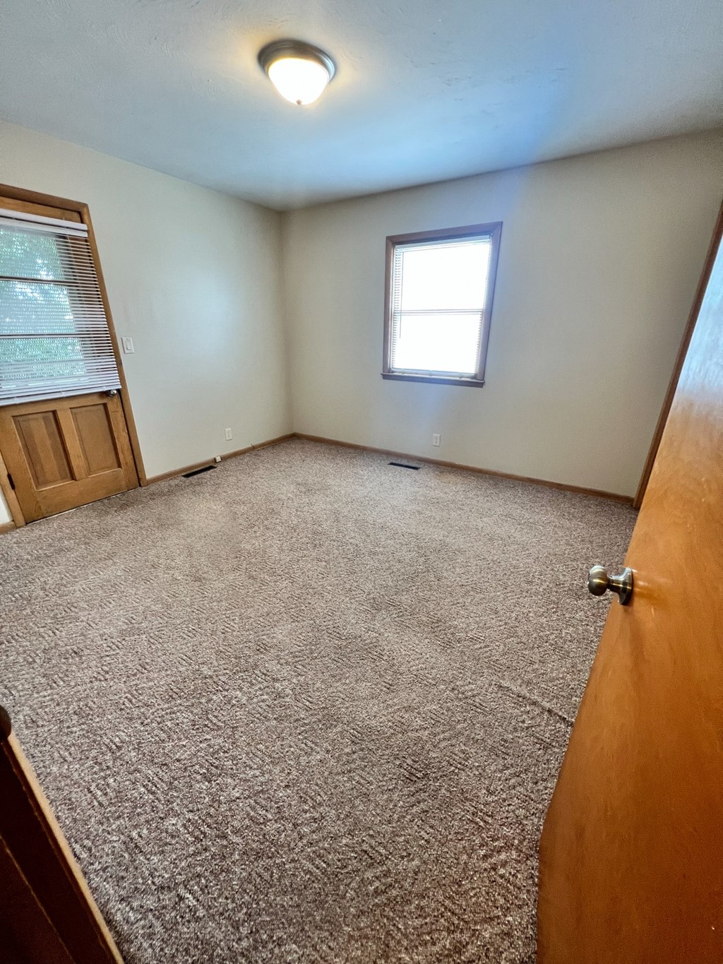 an empty room with a door and a window