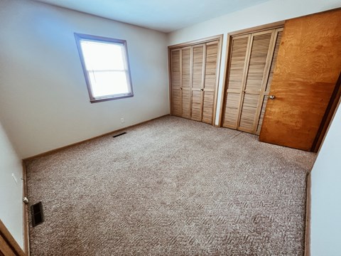 an empty room with a closet and a window