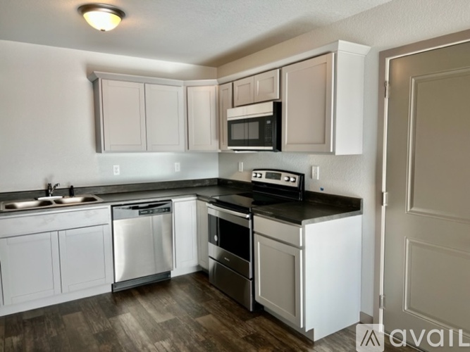 A kitchen with white cabinets and a black countertop.