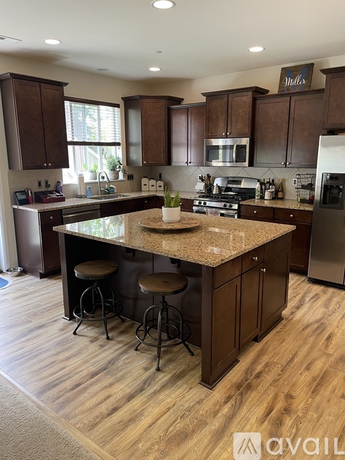 A kitchen with wooden cabinets and a granite countertop.