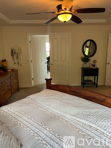 A bedroom with a large bed and a ceiling fan.