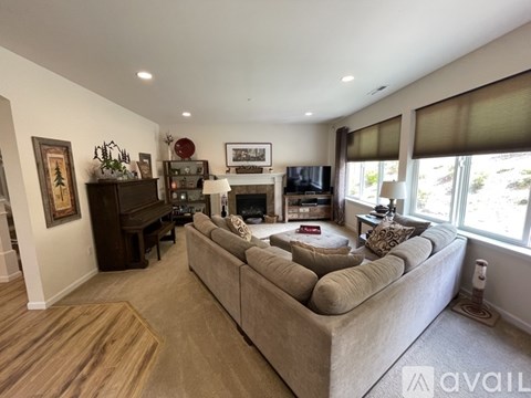 A living room with a couch, a fireplace, and a painting on the wall.