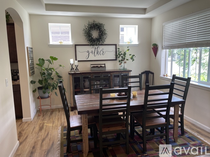 A dining room with a wooden table and chairs.