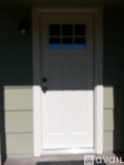A white door with a black handle and a small window above it.