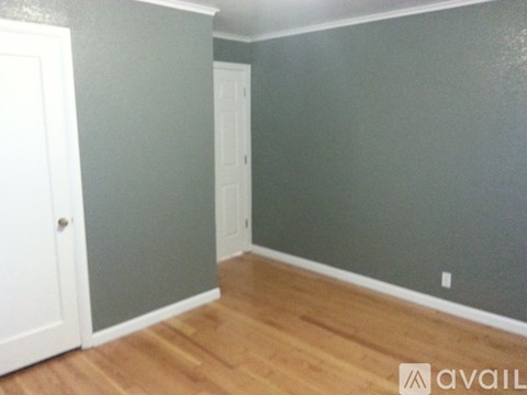 A room with a wooden floor and a white door.