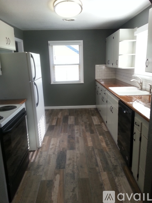 A kitchen with a white refrigerator and wooden floors.