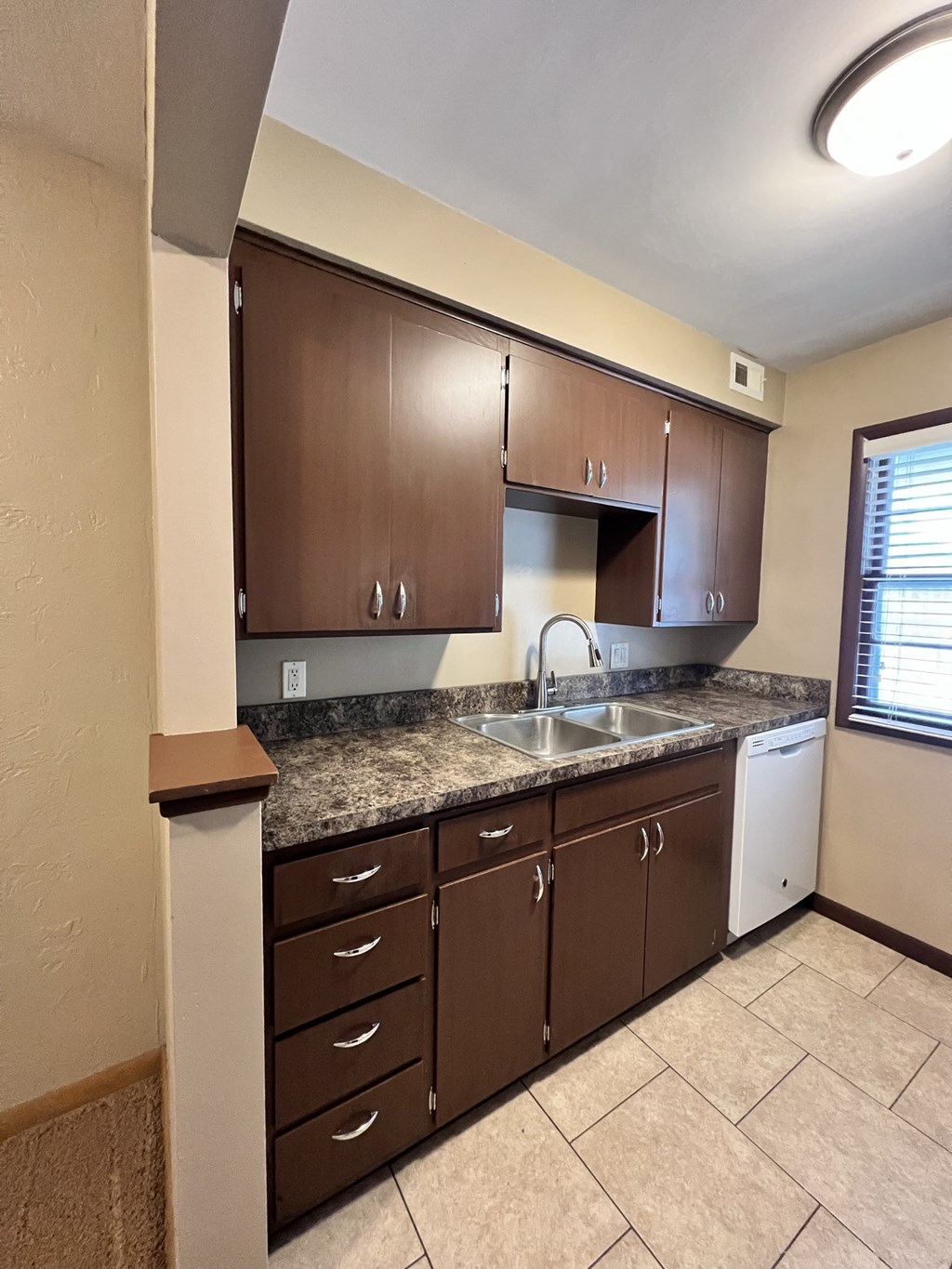 an empty kitchen with a sink and counter top