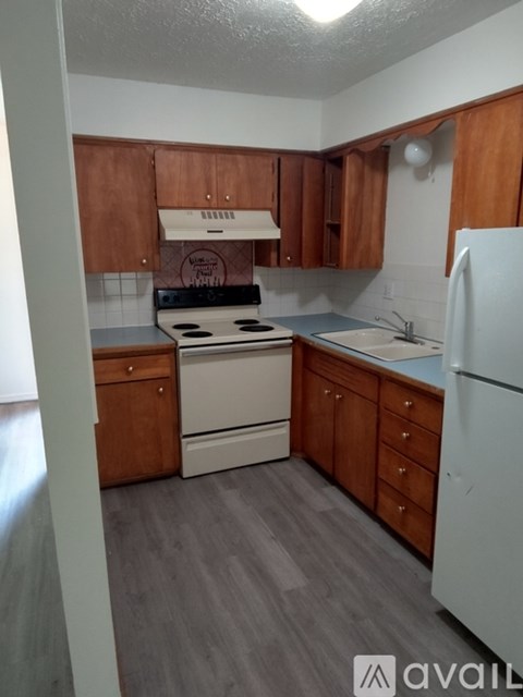 A kitchen with wooden cabinets and a white refrigerator.