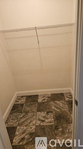 A hallway with a tiled floor and a white door.