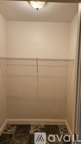 A small, empty room with a marble floor and a white wall.
