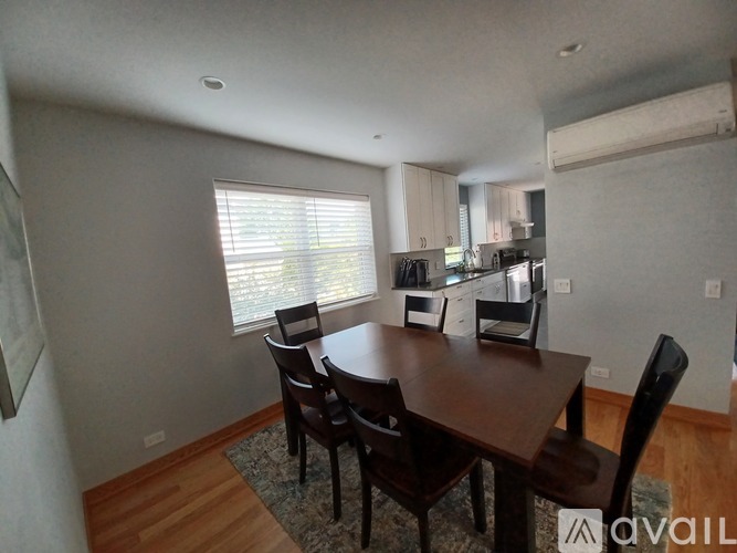 A dining room with a table and chairs.