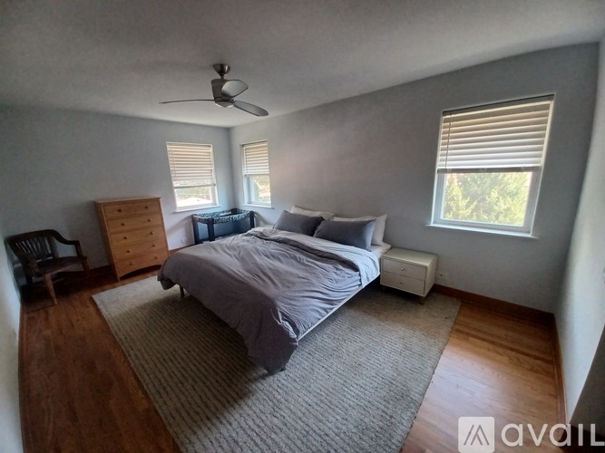 A bedroom with a bed, dresser, and window.