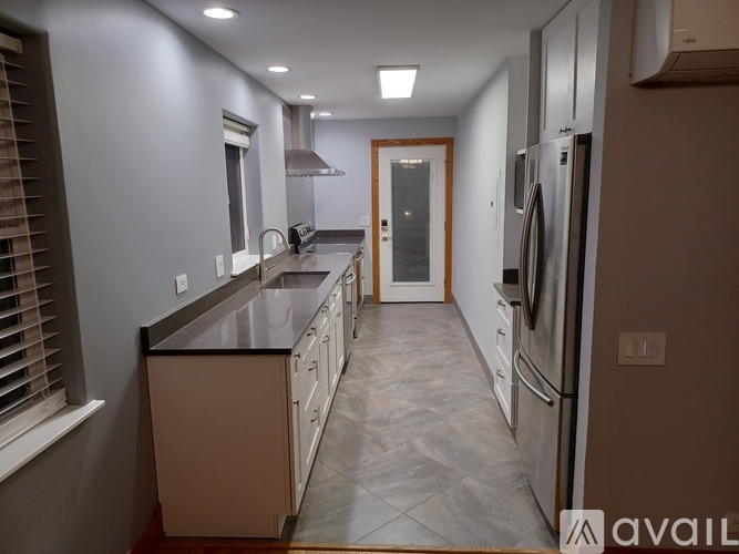 A modern kitchen with a refrigerator on the right side.