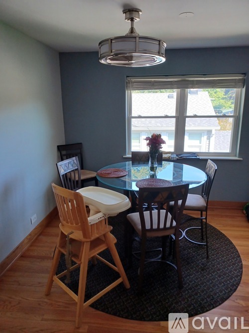 A dining room with a table and chairs.