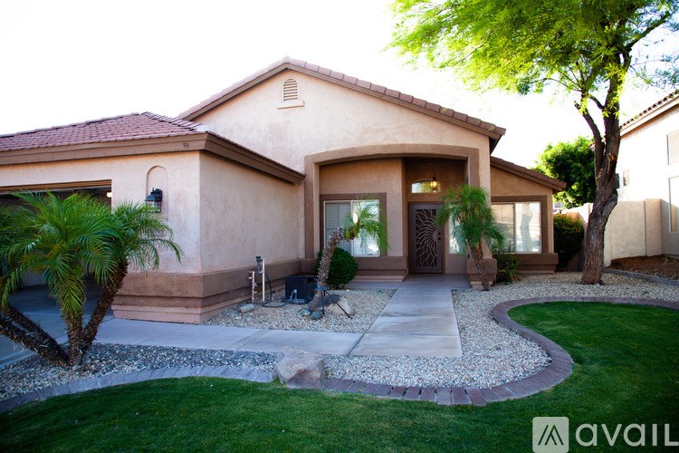 A house with a red roof and a tree in front of it.