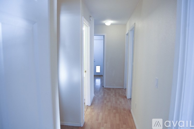 A hallway with a door on the left and a window on the right.