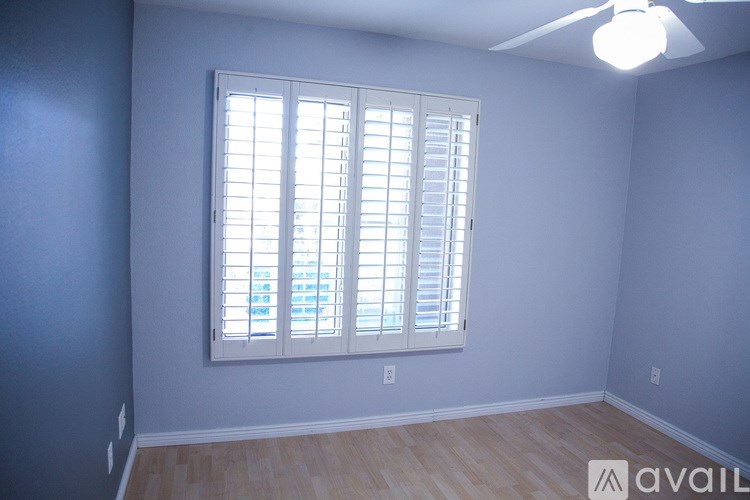 A room with a window and a ceiling fan.