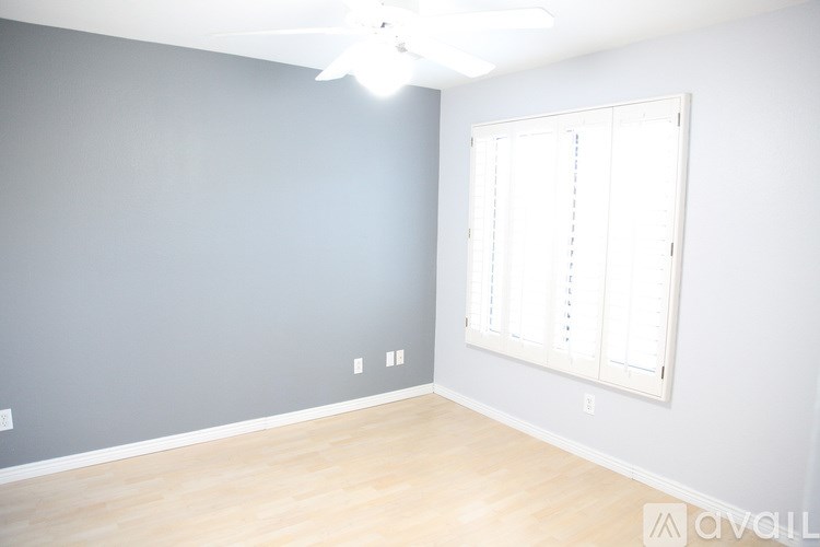 A room with a window and a ceiling fan.