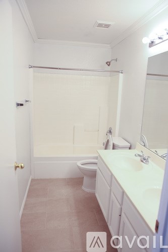 A bathroom with a toilet, sink, and mirror.