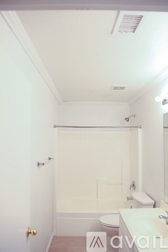 A bathroom with a toilet, sink and shower.