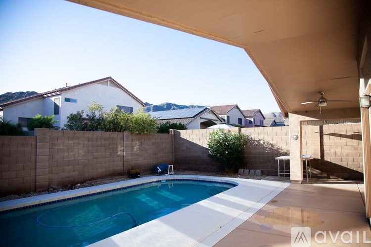 A pool in a backyard with a house in the background.