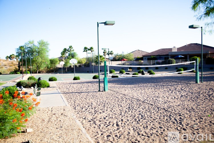 A tennis court with a green fence and a green light post.