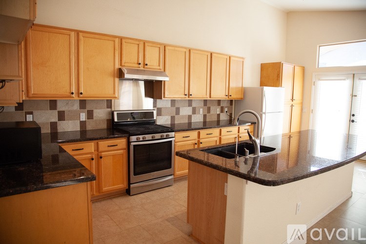 A kitchen with wooden cabinets and a black countertop.