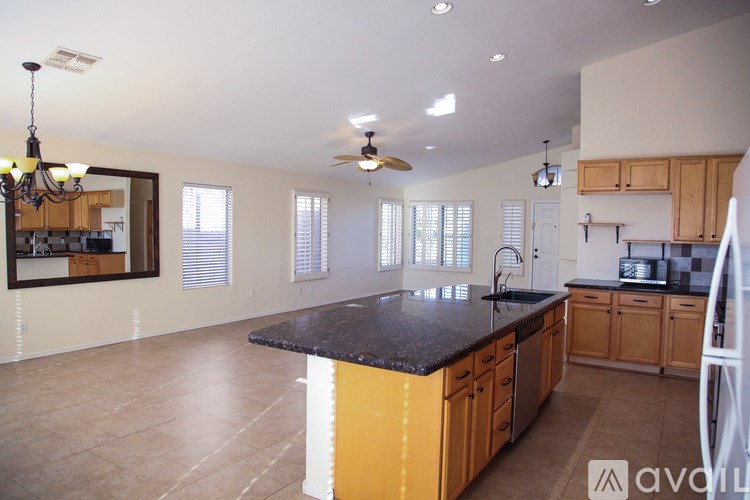 A kitchen with wooden cabinets and a black countertop.