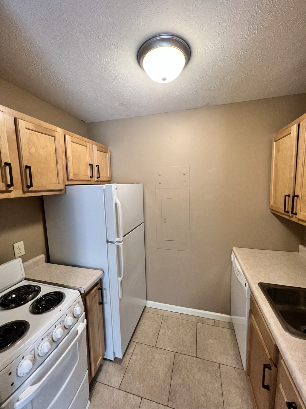 an empty kitchen with a stove refrigerator and sink