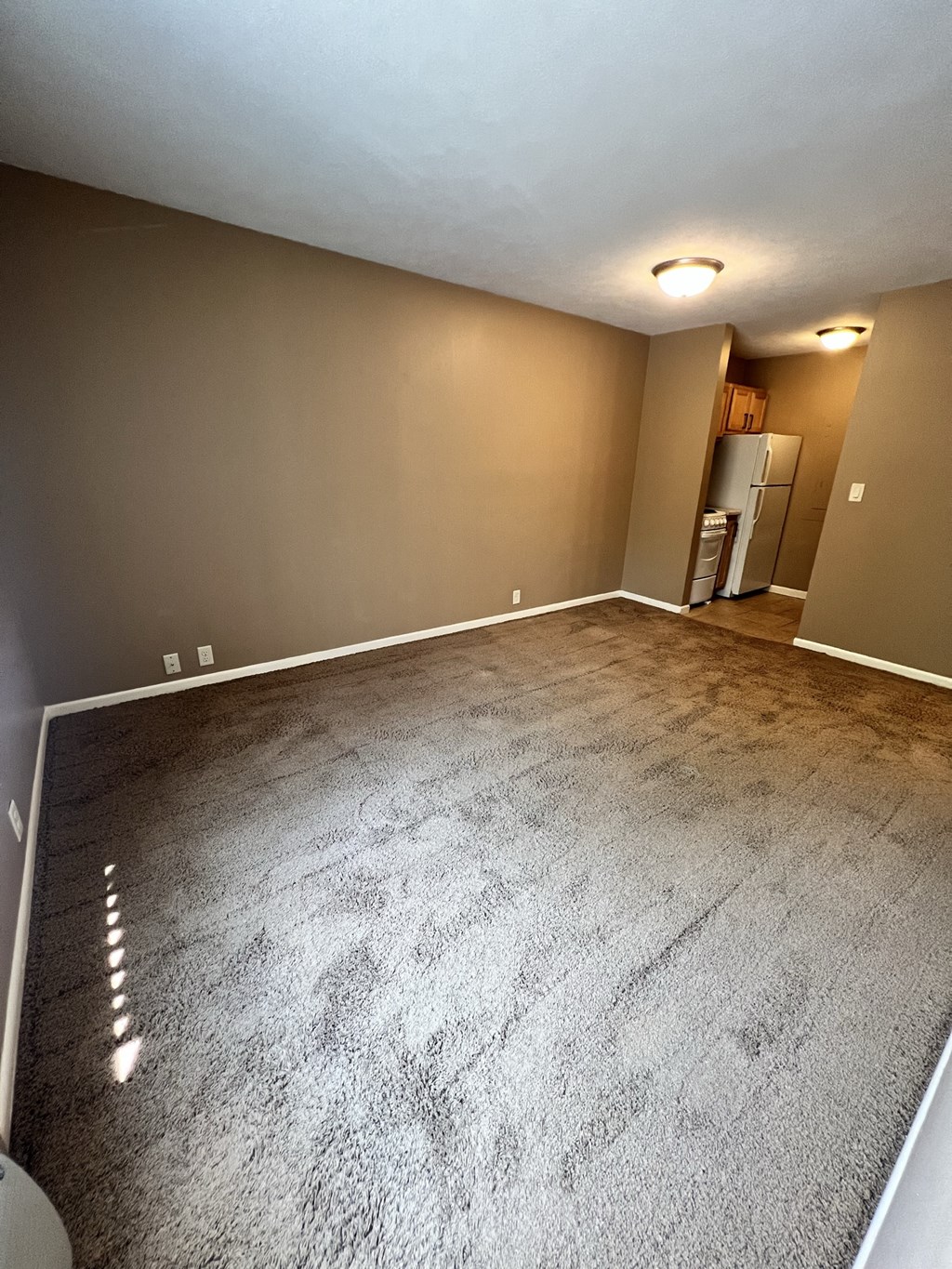 an empty living room with a carpeted floor