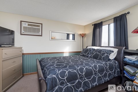 A bedroom with a bed, dresser, and window.