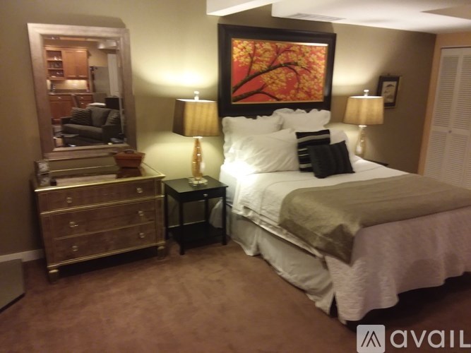 A bedroom with a bed, nightstand, and lamp.