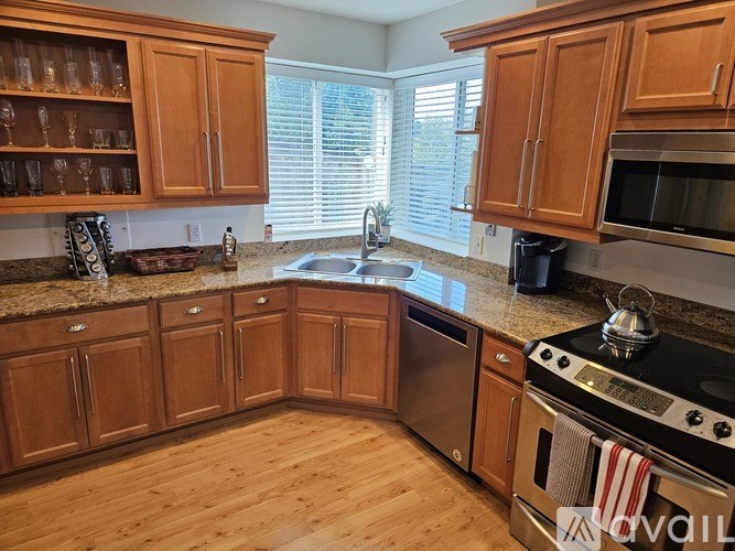 A kitchen with wooden cabinets and a granite countertop.