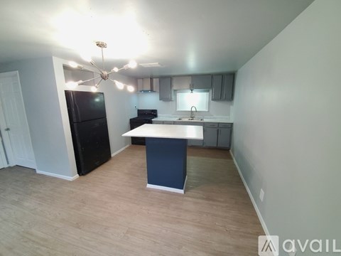 A kitchen with a black fridge and a white countertop.