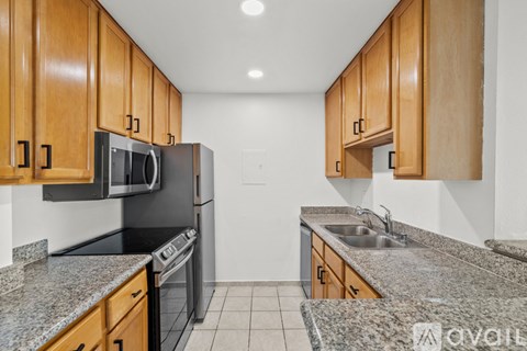 A kitchen with wooden cabinets and granite countertops.