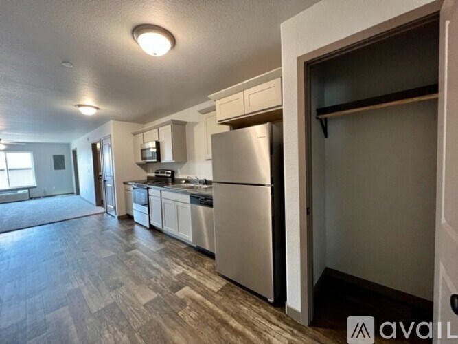 A kitchen with a refrigerator, oven, and microwave.