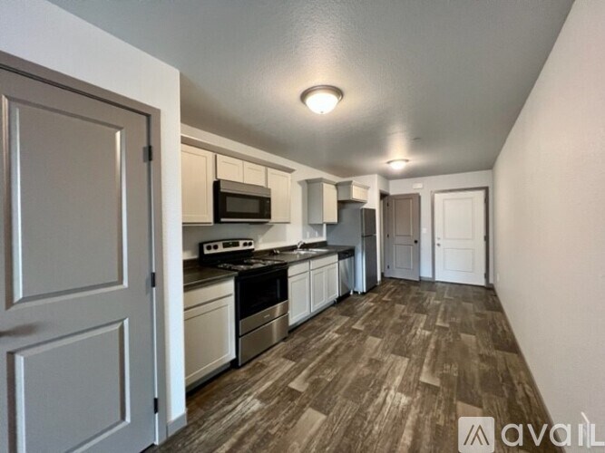 A kitchen with a microwave, oven, and sink.