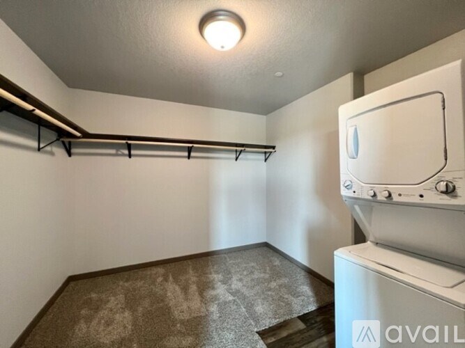 A room with a white appliance and a shelf.