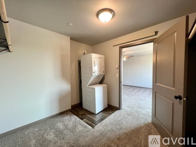 A small, empty room with a white cabinet and a carpeted floor.