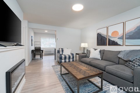 A living room with a grey couch and a wooden coffee table.