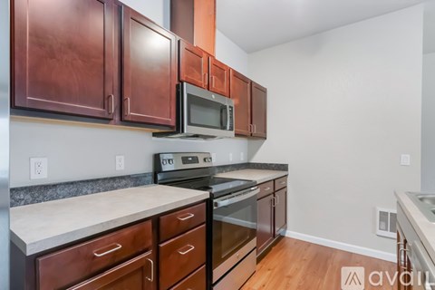 A kitchen with brown cabinets and a stove top oven.