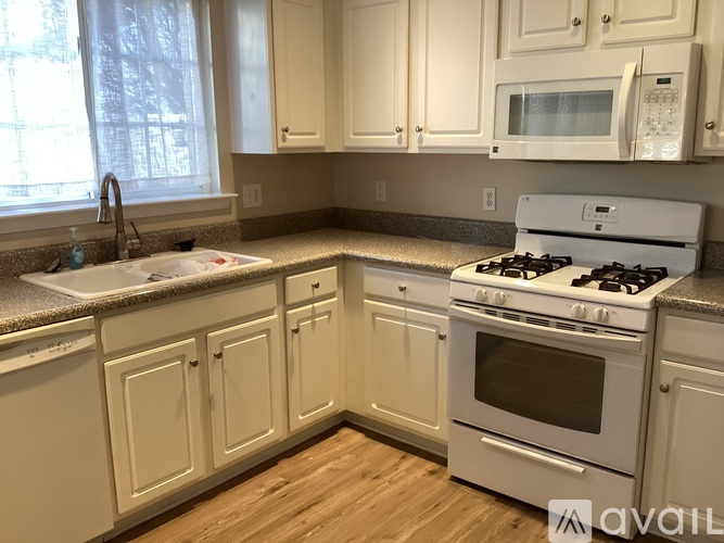 A kitchen with white cabinets and appliances.