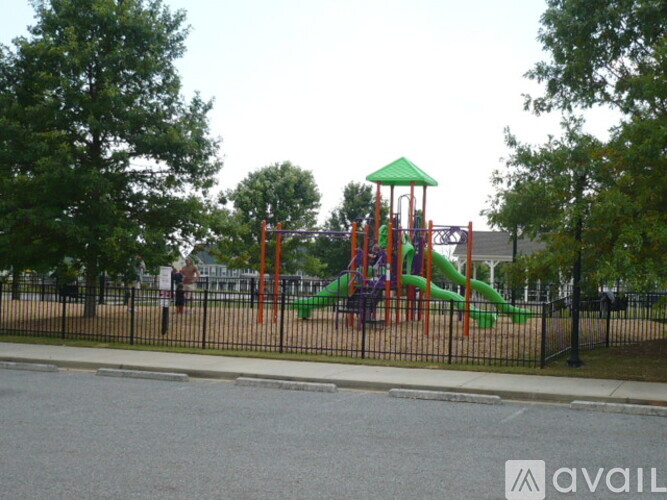 A playground with a green slide and a red and orange structure.