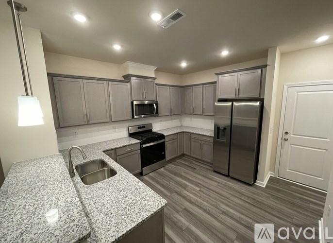 A kitchen with granite countertops and stainless steel appliances.