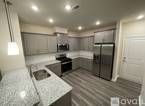 A kitchen with granite countertops and stainless steel appliances.
