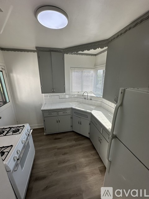 A kitchen with a white stove and cabinets.