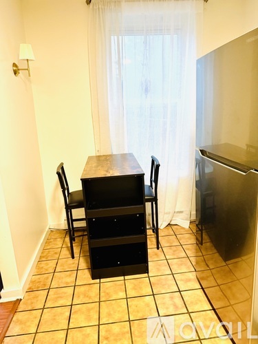 A kitchen with a table and chairs.