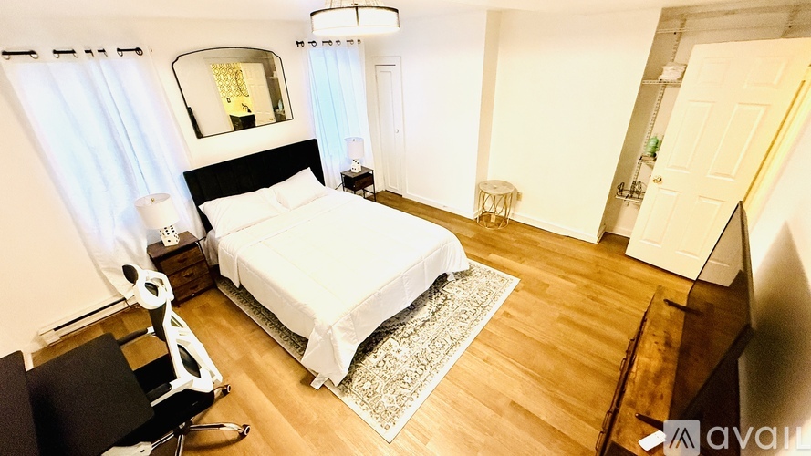 A bedroom with a bed, chair, and window.