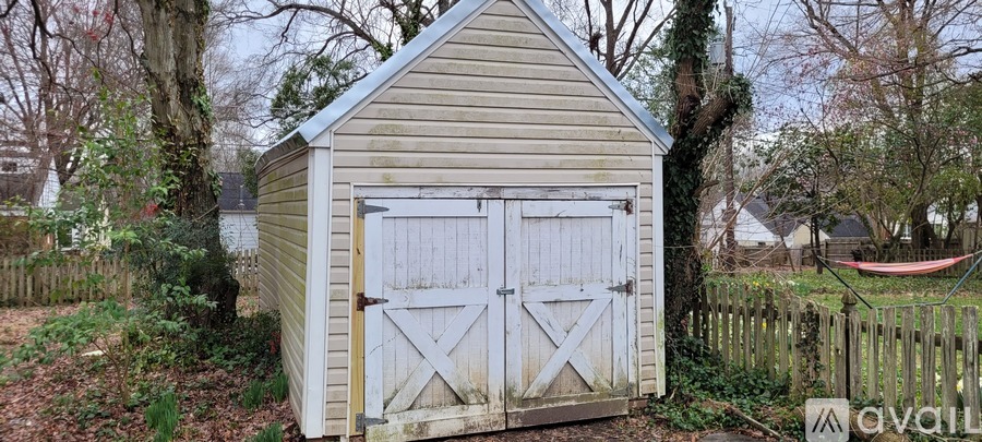 A shed with a white door and a wooden fence in front of it.
