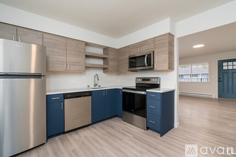 A kitchen with blue cabinets and a stainless steel refrigerator.